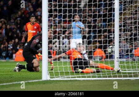 Le Sergiy Kryvtsov de Shakhtar Donetsk se retire de la ligne après que le gardien de but Andrei Pyatov renverse le ballon Banque D'Images