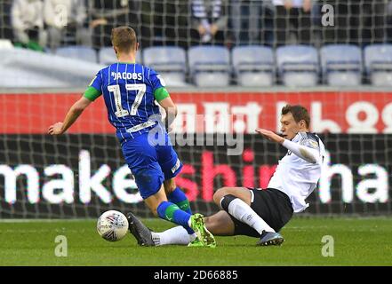 Le Michael Jacobs (à gauche) de Wigan Athletic est abordé par Krystian Bielik, du comté de Derby Banque D'Images