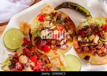 Saucisses mexicaines longaniza et steak de rue tacos campechanos avec chicharron rinds de porc et sauce tomatillo verde Banque D'Images