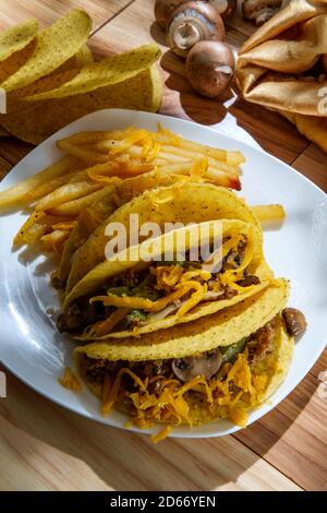 Cuisine mexicaine-américaine de Philly Cheesesteak tacos avec oignons poivrons et champignons, frites sur le côté Banque D'Images