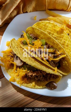 Cuisine mexicaine-américaine de Philly Cheesesteak tacos avec oignons poivrons et champignons, frites sur le côté Banque D'Images