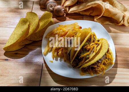 Cuisine mexicaine-américaine de Philly Cheesesteak tacos avec oignons poivrons et champignons, frites sur le côté Banque D'Images