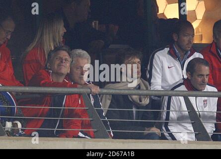 L'ancien président américain Bill Clinton (au centre à gauche) avec la rock star britannique Mick Jagger (au centre à droite) dans les tribunes. Banque D'Images