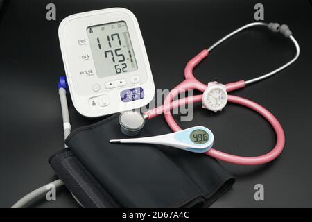 Tensiomètre, stéthoscope et thermomètre sur fond noir Banque D'Images