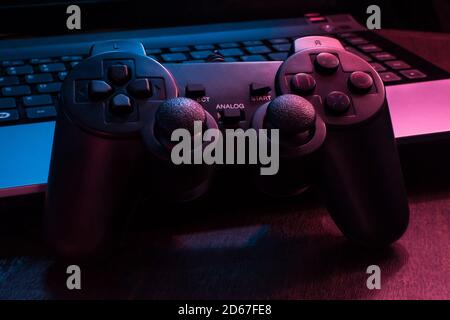 Manette de jeu sous les lumières bleues et rouges dans une obscurité chambre Banque D'Images