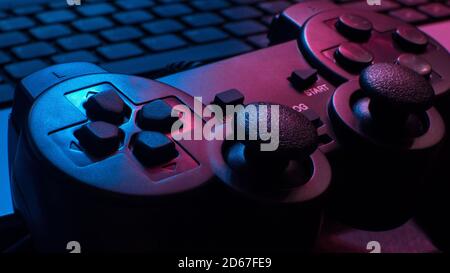 Manette de jeu sous les lumières bleues et rouges dans une obscurité chambre Banque D'Images