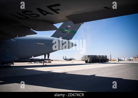 Les membres de l'équipage C-17 Globemaster III guident un chargeur de fret vers la rampe de déchargement de la 332e Escadre expéditionnaire aérienne, Asie du Sud-Ouest, le 3 octobre 2020. Le 816e Escadron de transport aérien expéditionnaire, déployé avec le US Air Forces Central, est responsable de la livraison de fret et de passagers aux bases américaines et des forces de la coalition dans l'ensemble de la zone de responsabilité du US Central Command. (É.-U. Photo de la Force aérienne par le Sgt. Larry E. Reid Jr.) Banque D'Images