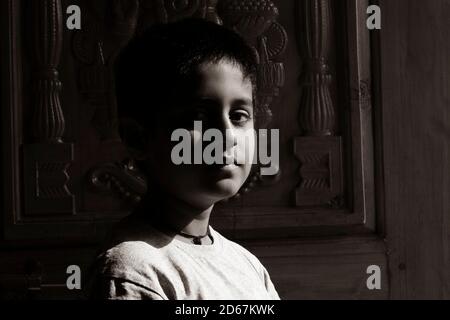 Gros plan d'un garçon indien au soleil du matin dans la maison photo monochrome, Kalaburagi, Karnataka/Inde-septembre 02.2020 Banque D'Images