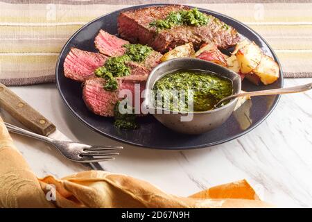 Chimichurri verde rare juteux steak grillé et pommes de terre rouge Banque D'Images