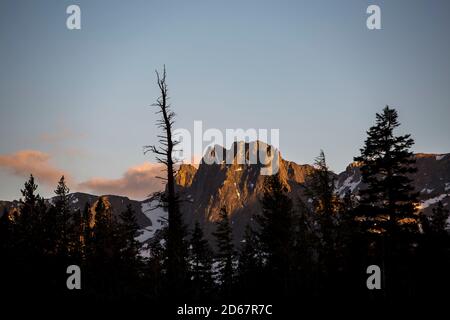 12 juin 2014, Mammoth Lakes, Californie, États-Unis : pins et montagnes enneigées au lac Mary au coucher du soleil, Mammoth Lakes. La Sierra abrite trois parcs nationaux, vingt zones sauvages et deux monuments nationaux. La Sierra Nevada est la plus haute chaîne de montagnes des États-Unis contigus. Mammoth Lakes se trouve au bord de la Caldera de la vallée de long et est géologiquement active. Les points forts sont la station de ski de Mammoth Mountain, au-dessus du sommet de Minaret, puis jusqu'au monument national Devils Postpile, avec accès à la région sauvage d'Ansel Adams. La région a des sources chaudes naturelles, des lacs, des sources de soda Banque D'Images