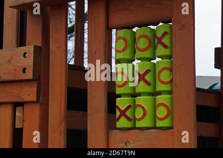 Jeu logique, TIC-tac-toe, jeu de hree-in-a-row avec des symboles rouge et orange appliqués aux cylindres verts sur le terrain de jeu dans la structure des échelles et des plates-formes Banque D'Images