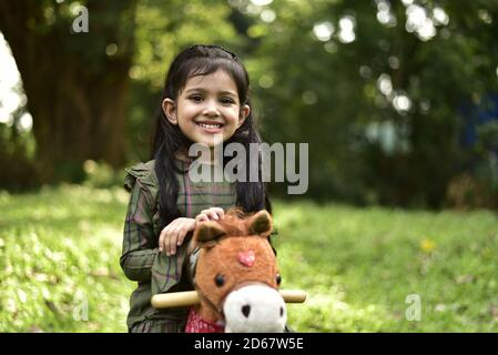 Un petit enfant heureux et un cheval à bascule. Banque D'Images