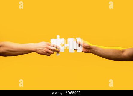Pièce de puzzle main homme reliant couple. Solutions d'affaires, cible, succès, objectifs et concepts de stratégie. Puzzle à connexion manuelle. Entreprise Banque D'Images