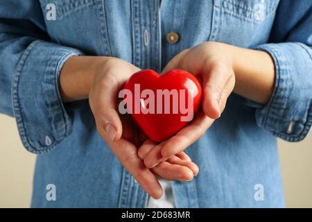 Femme en jean tient coeur rouge, gros plan Banque D'Images