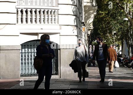 Madrid, Espagne. 14 octobre 2020. Des personnes portant des masques de visage marchent dans une rue à Madrid, Espagne, 14 octobre 2020. Le ministère espagnol de la Santé a signalé mercredi 11,970 nouveaux cas de coronavirus, ce qui porte le nombre total d'infections dans le pays à 908,056. Credit: Meng Dingbo/Xinhua/Alay Live News Banque D'Images