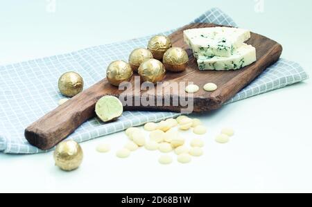 truffes au chocolat fabriquées à partir de chocolat blanc et de fromage bleu d'or sur une planche en bois Banque D'Images