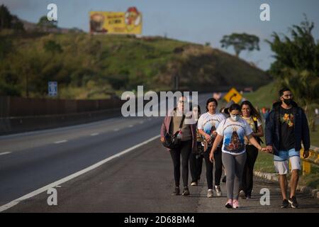 Aparecida, Brésil. 12 octobre 2020. Les pèlerins marchent le long d'une autoroute jusqu'à la basilique de Nossa Senhora Aparecida, pendant la journée de Nossa Senhora Aparecida, le Saint patron du Brésil. Pour la première fois dans l'histoire de la basilique, en raison de la pandémie de Corona, les masses ont dû être célébrées derrière des portes fermées ou en présence d'un petit nombre de personnes. Credit: Fernando Souza/dpa/Alay Live News Banque D'Images