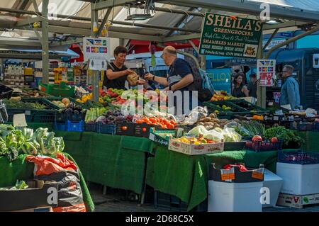 Stall Holder vendant des fruits et légumes frais de légumes aux étals de marché en plein air York North Yorkshire Angleterre Royaume-Uni GB Grande-Bretagne Banque D'Images