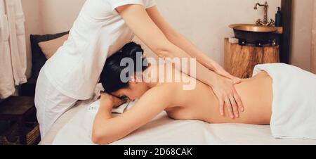 Magnifique brunette bénéficiant d'un massage Sabay dans un salon spa oriental. Le massage Sabai est une combinaison de massage traditionnel thaïlandais et balinais Banque D'Images