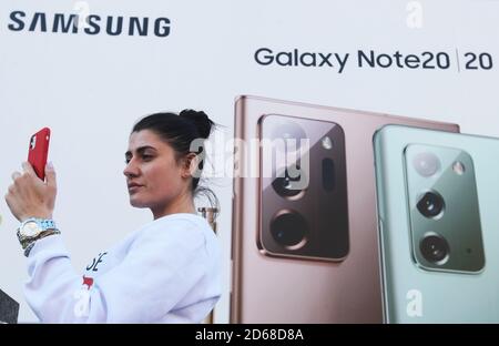 Kiev, Ukraine. 14 octobre 2020. Une femme prend un selfie devant un tableau avec une publicité de Samsung Galaxy Note 20 smartphone dans le centre-ville. Crédit : SOPA Images Limited/Alamy Live News Banque D'Images