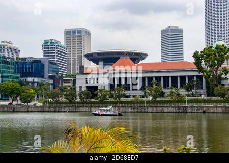 Vue sur la rivière Singapour. Le contexte est le Parlement de Singapour. Il y a un bateau de patrouille de la police de Singapour sur le fleuve. Banque D'Images