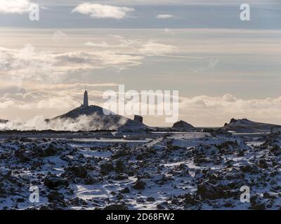 Phare de Reykjanviti avec de la vapeur survolant les sources chaudes de la zone géothermique Gunnuhver et la centrale géothermique de Teh Sudurnes. europe, non Banque D'Images