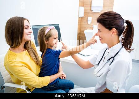 Pédiatre sympathique s'amusant avec son enfant patient à l'hôpital. Consultation, santé des enfants. Banque D'Images