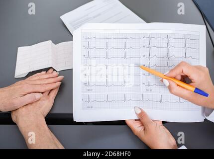 Médecin expérimenté portant des résultats d'électrocardiogramme d'une femme âgée. Diagnostic et traitement des arythmies, des maladies coronariennes et du cœur f Banque D'Images