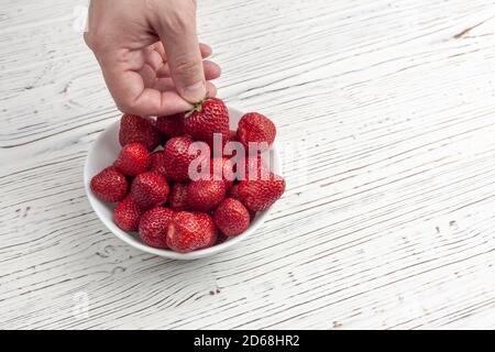 la main des hommes prend des fraises Banque D'Images