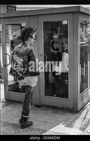 Punk fille attendant devant un coffre téléphonique (Berlin Ouest) Banque D'Images