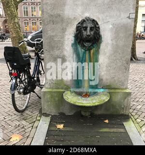 Une ancienne fontaine ou pompe en forme de lion avec un vélo garée à côté dans la ville d'Utrecht, aux pays-Bas Banque D'Images