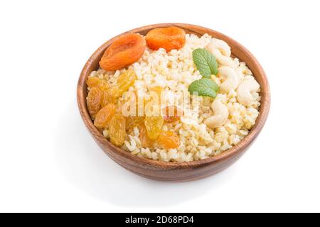 Porridge bulgur aux abricots secs, raisins secs et noix de cajou dans un bol en bois isolé sur fond blanc. Vue latérale, gros plan. Cuisine traditionnelle turque Banque D'Images