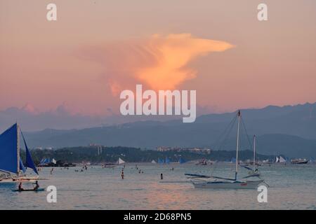 Boracay, Philippines - 27 janvier 2020 : coucher de soleil sur l'île de Boracay. Voile et autres bateaux traditionnels avec des touristes sur la mer sur le fond de Banque D'Images