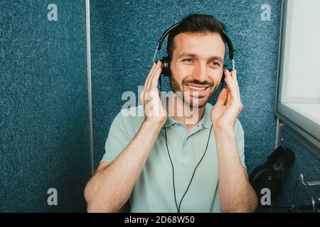 Examen auditif de l'audiomètre. Homme de course mixte portant un casque spécial et obtenant un test auditif dans la salle audio spéciale Banque D'Images