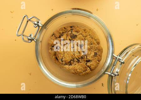 Pot en verre avec biscuits d'avoine, vue de dessus sur fond orange Banque D'Images