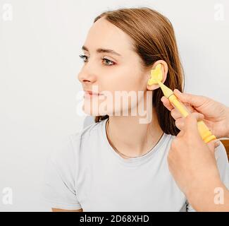 Bouchons d'oreilles moulés personnellement. Processus de fabrication des bouchons d'oreille à partir d'une impression d'oreille d'une femme. Audiologie. Partie de l'ensemble Banque D'Images