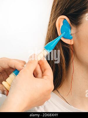 Bouchons d'oreilles moulés personnellement. Processus de fabrication des bouchons d'oreille à partir d'une impression d'oreille d'une femme. Audiologie. Partie de l'ensemble Banque D'Images