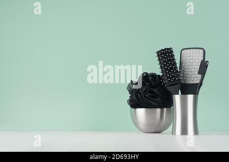 Articles de toilette noirs pour le soin du corps et de la peau en vert clair doux menthe menl'intérieur de la salle de bains sur table en bois blanc - éponge de bain, peigne, brosse à dents, pierre ponce. Banque D'Images