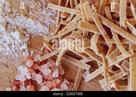 Ingrédients frais de pâtes maison disposés sur une table en bois prête à être préparée Banque D'Images