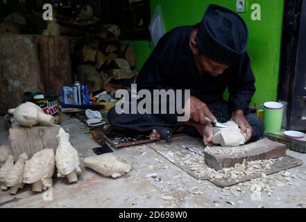 Un artisan Entang Sutisna (73) travaille sur la fabrication de marionnettes "wayang golek" ou golek à partir de bois de bole (Alstonia scholaris) à l'atelier d'art et d'artisanat des médias, à Loji Village, Bogor City, West Java, 15 octobre 2020. La marionnette traditionnelle javanaise occidentale 'Wayang Golek' vendue à plusieurs pays comme les pays-Bas, le Japon, la Corée, la Suisse, l'Allemagne et les États-Unis. La production de wayang golek se poursuit même si les ventes ont diminué de 95 pour cent en raison de la pandémie COVID-19. (Photo par Adrian/INA photo Agency/Sipa USA) Banque D'Images