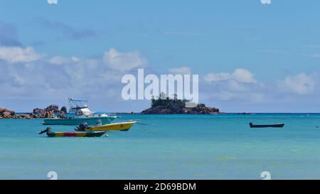 Anse Volbert, Praslin, Seychelles - 09/25/2018: Bateaux amarrés dans la mer turquoise sur la plage tropicale Anse Volbert avec la petite île Saint-Pierre. Banque D'Images