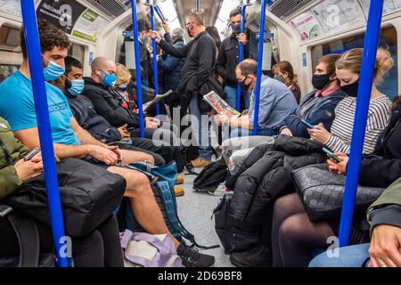 Londres, Royaume-Uni. 15 octobre 2020. Le nombre de passagers reste bas sur le métro, mais augmente maintenant et les trains sont modérément occupés, en particulier en heure de pointe. Tout comme le gouvernement commence à resserrer ses directives sur le coronavirus (Covid 19). Ceux qui voyagent portent surtout des masques après qu'ils sont devenus obligatoires dans les transports publics. Crédit : Guy Bell/Alay Live News Banque D'Images