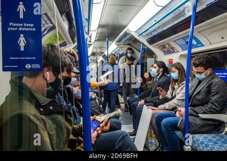 Londres, Royaume-Uni. 15 octobre 2020. Le nombre de passagers reste bas sur le métro, mais augmente maintenant et les trains sont modérément occupés, en particulier en heure de pointe. Tout comme le gouvernement commence à resserrer ses directives sur le coronavirus (Covid 19). Ceux qui voyagent portent surtout des masques après qu'ils sont devenus obligatoires dans les transports publics. Crédit : Guy Bell/Alay Live News Banque D'Images