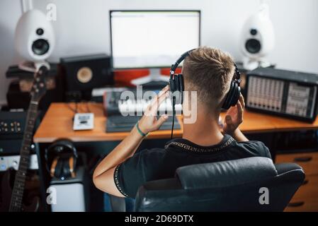 Ingénieur du son dans les écouteurs travaillant et mélangeant de la musique à l'intérieur le studio Banque D'Images