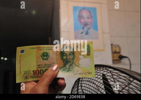 femme tenant une note de banque vietnamienne de dong dans sa main Banque D'Images