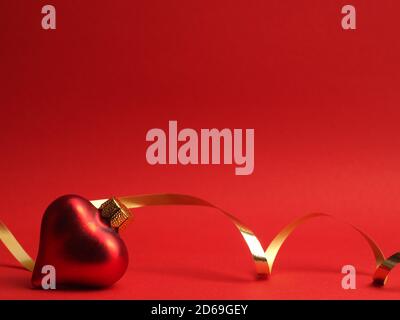 Boules de Noël vintage en forme de coeur sur un fond rouge avec espace pour votre texte ou image, concept de vacances saisonnières Banque D'Images
