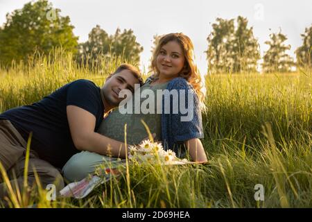 Le père à être touche le ventre de sa femme enceinte. Il l'embrasse doucement et l'embrasse. Banque D'Images