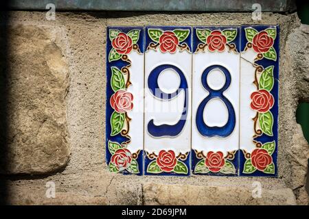 Gros plan de la maison numéro 98 (quatre-vingt-dix-huit) sur le mur dans un petit village. Ligurie, Italie, Europe Banque D'Images