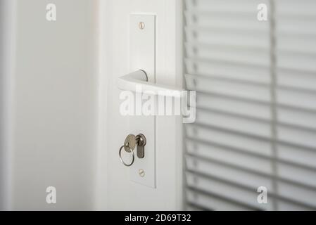 Poignée de porte et une clé sur une porte en plastique Banque D'Images