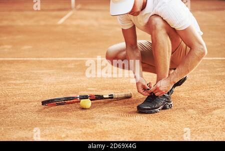 Préparation. Un jeune joueur de tennis en vêtements de sport se trouve sur le court à l'extérieur Banque D'Images